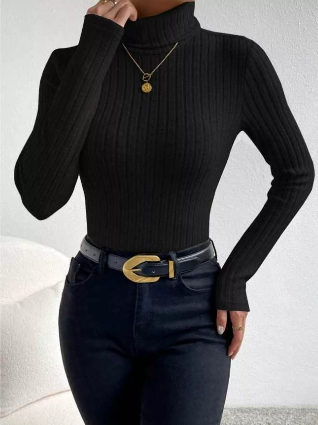 Woman wearing a black ribbed turtleneck sweater