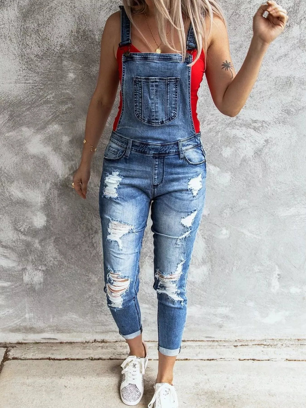 woman wearing relaxed fit distressed denim overalls