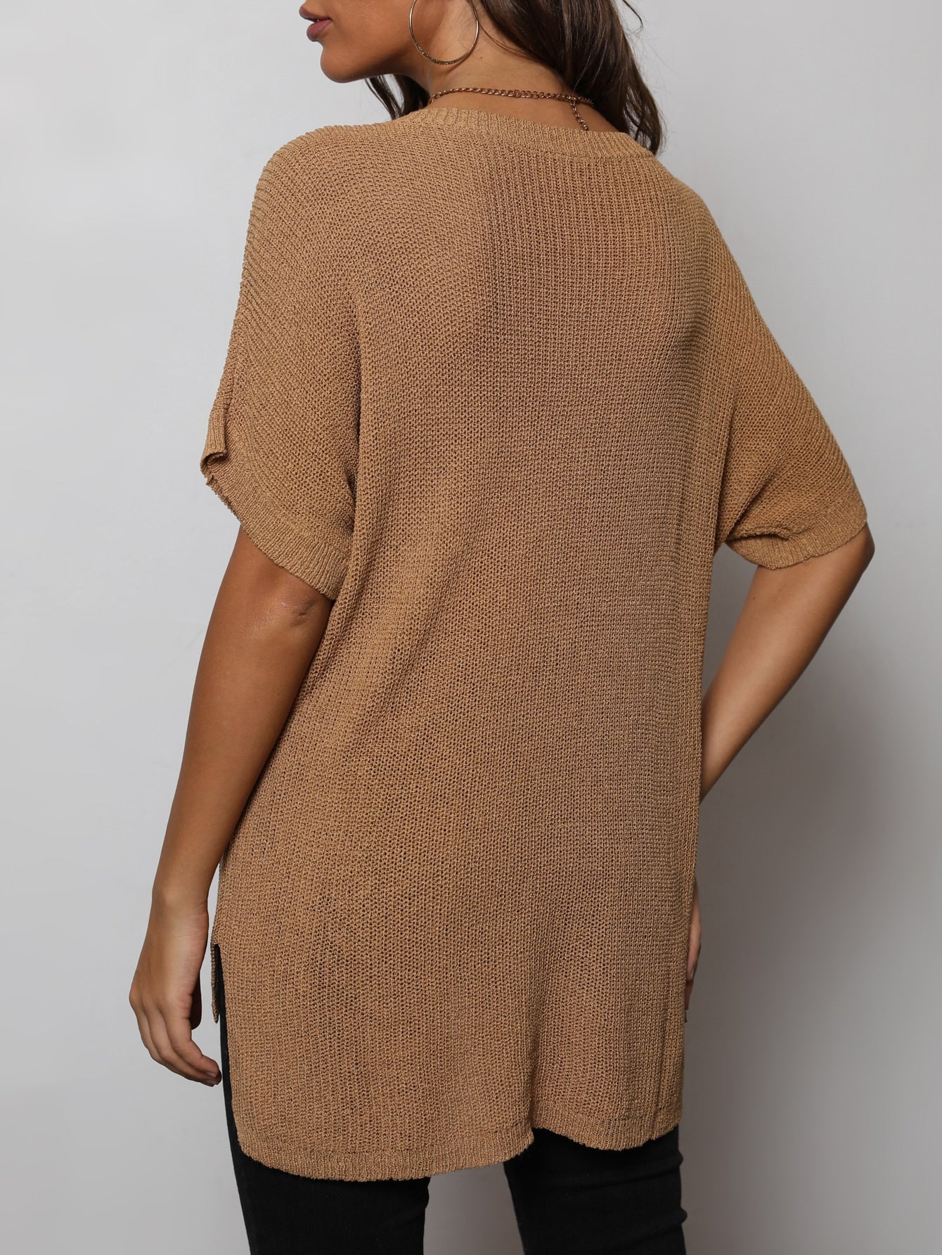 Woman wearing a camel color high low knit top