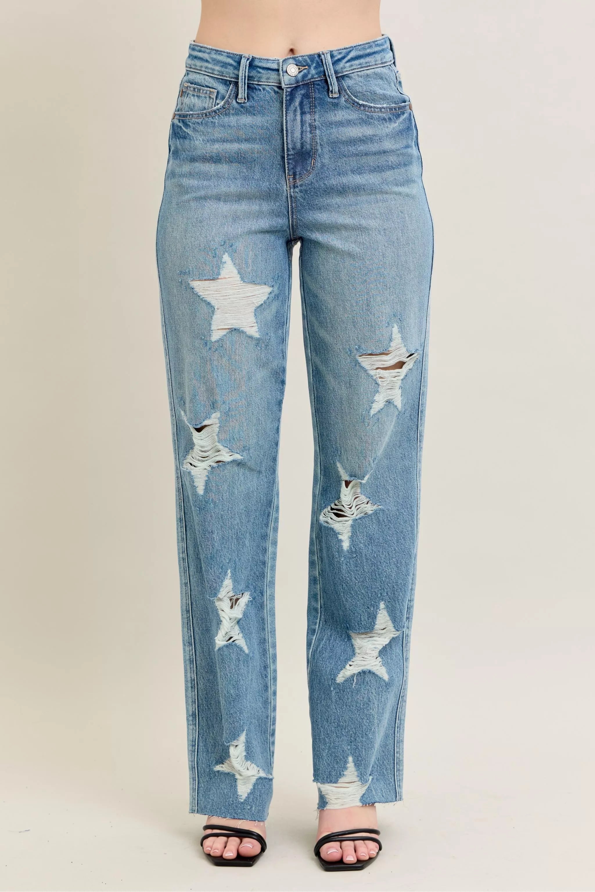 woman wearing high waist destroyed 90's jeans with star pattern detail