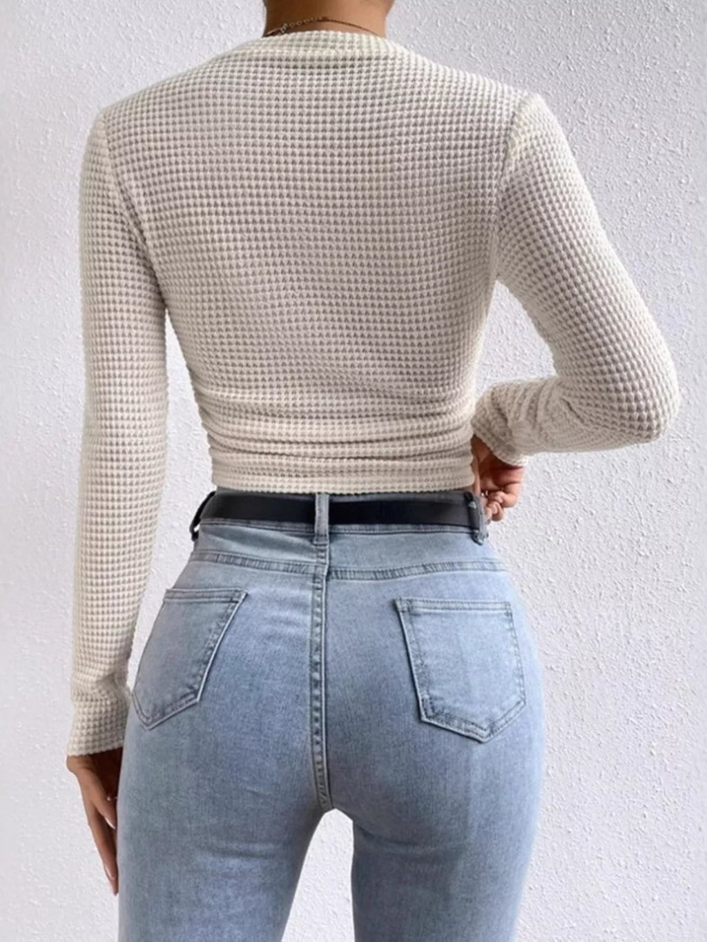 Woman wearing a tan long sleeve fitted waffle knit top