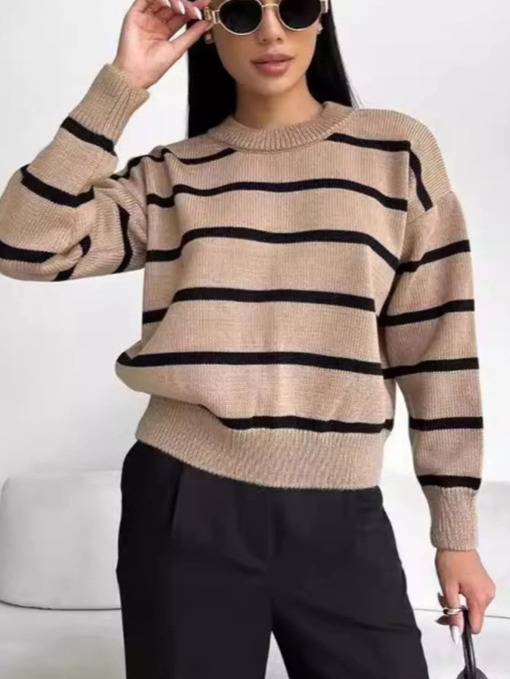 Woman wearing a neutral striped round neck sweater