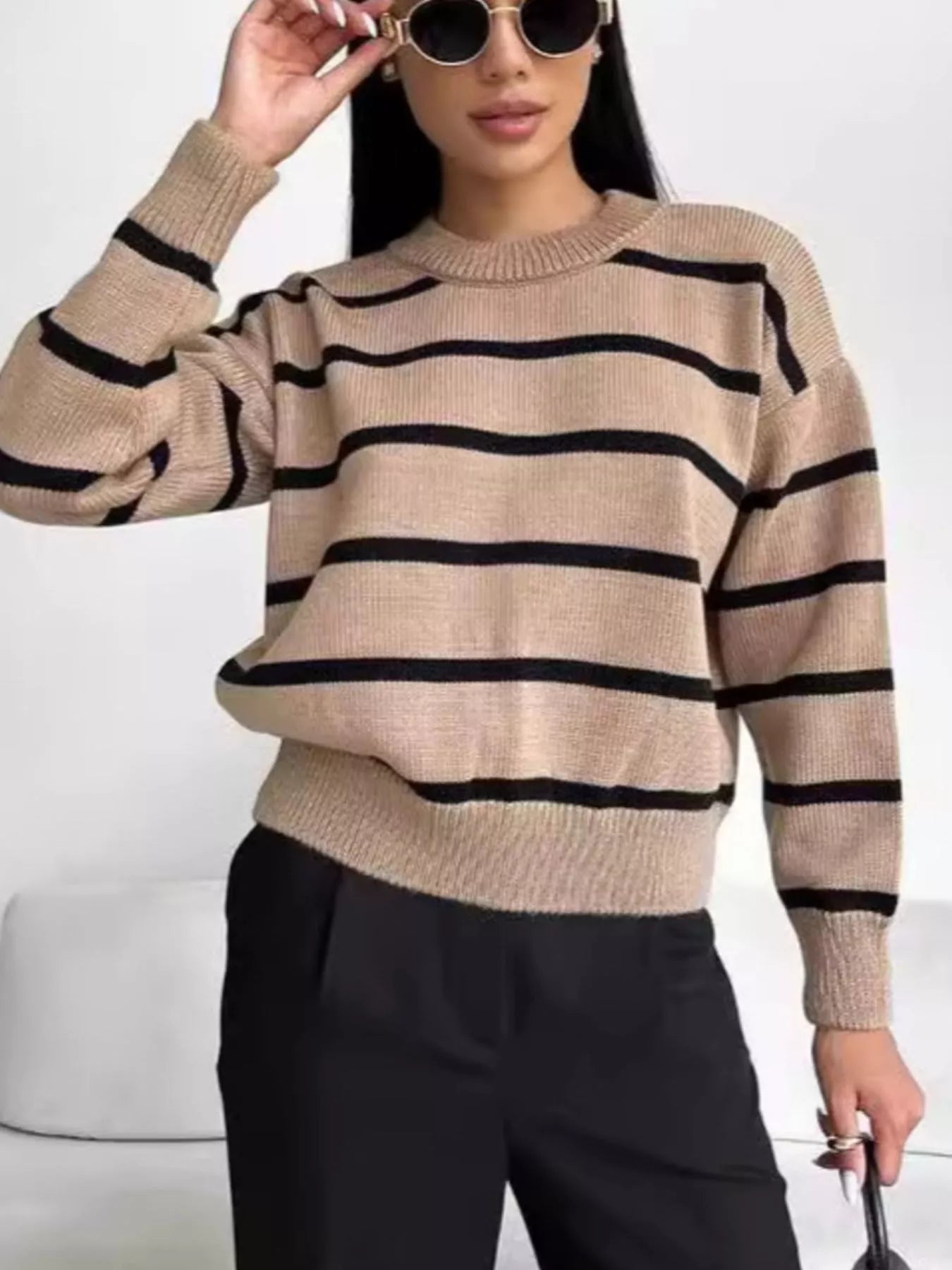 Woman wearing a neutral striped round neck sweater