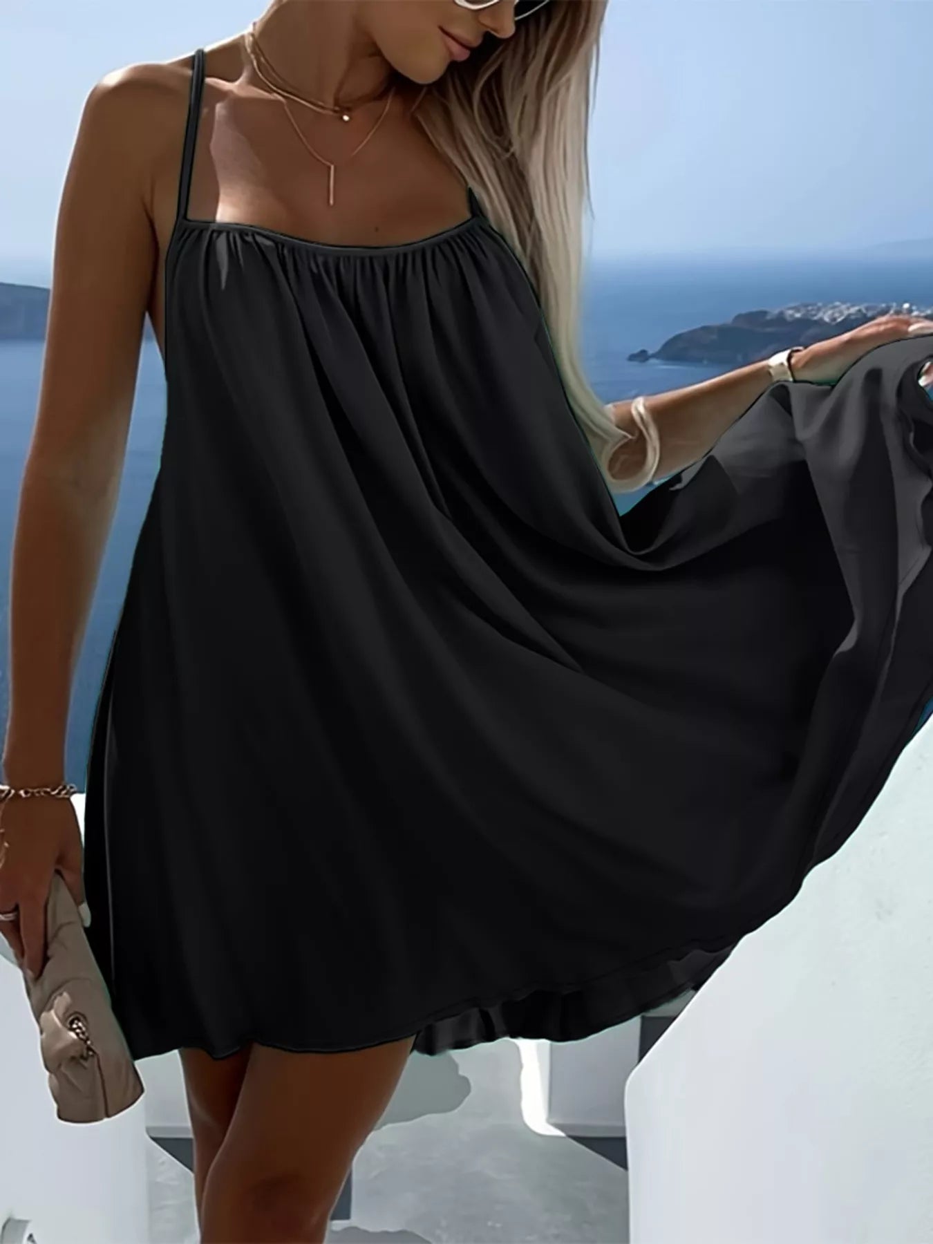 Woman wearing a sleeveless flowy mini dress 