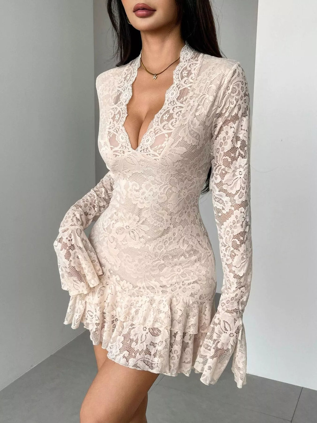 Woman wearing a white lace long sleeve mini dress