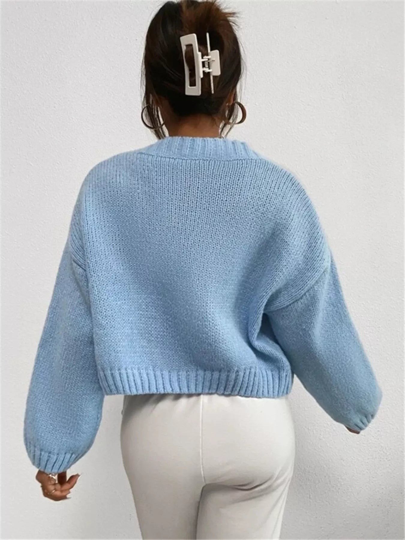woman wearing a baby blue button up cloud pattern fuzzy knit cardigan