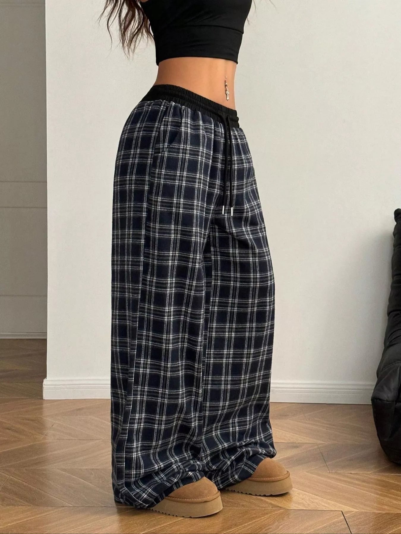 Model wearing black plaid relaxed fit wide-leg lounge pants with drawstring waist and pockets
