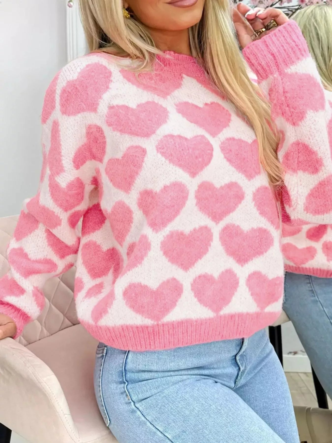 woman wearing a trendy pink and white heart pattern sweater
