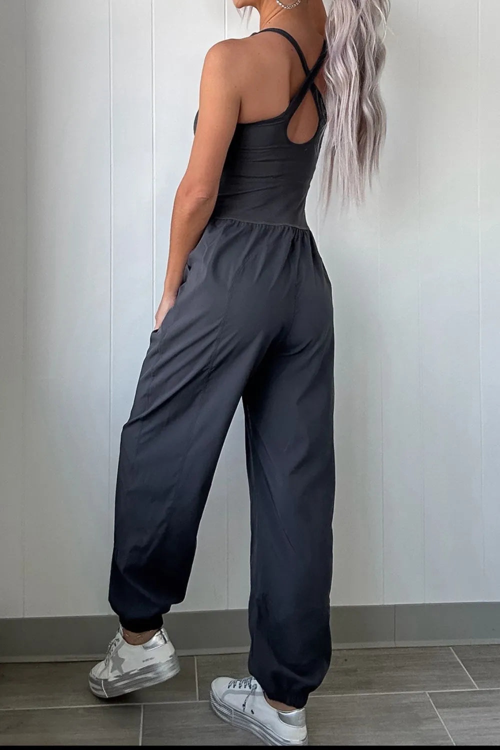 woman wearing a cutout sculpt activewear jumpsuit with criss cross back detail