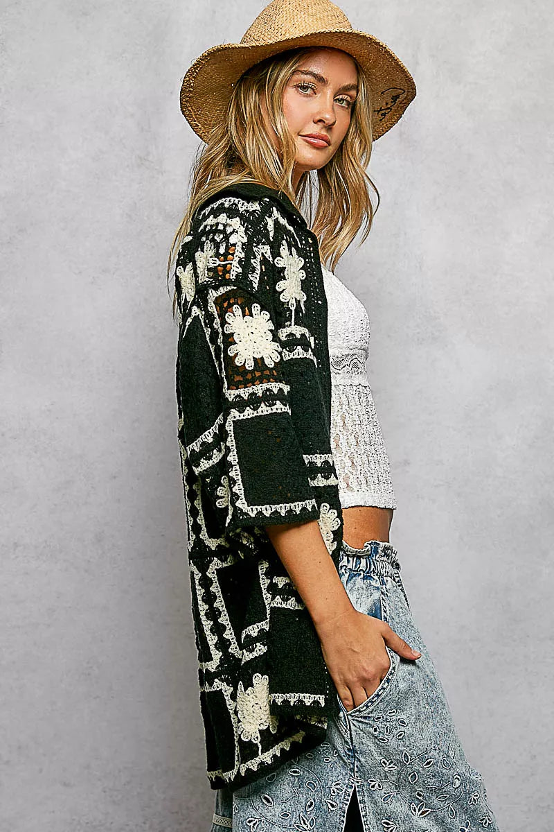 woman wearing a crochet black and white button down cardigan