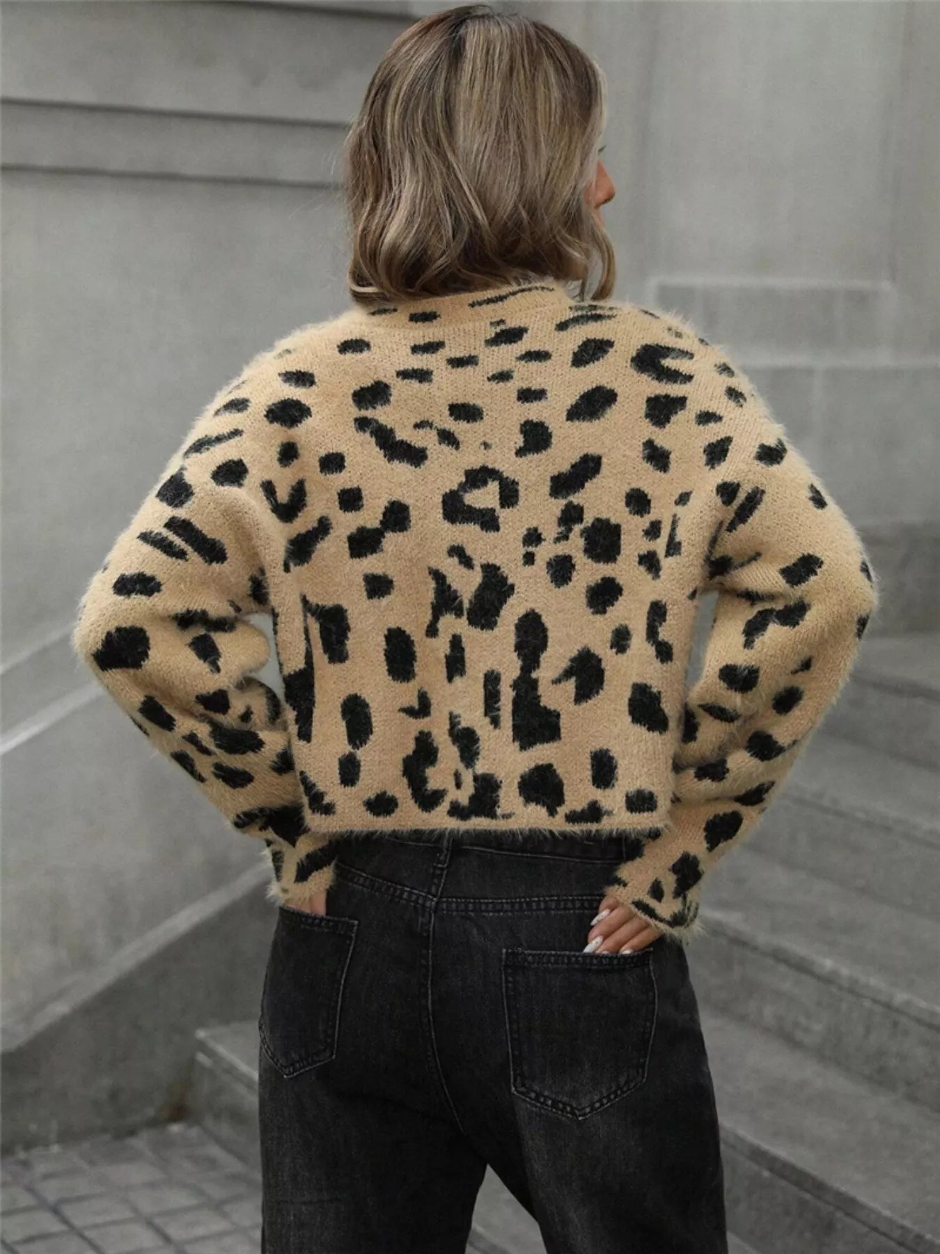 woman wearing a cropped fuzzy leopard pattern knit sweater