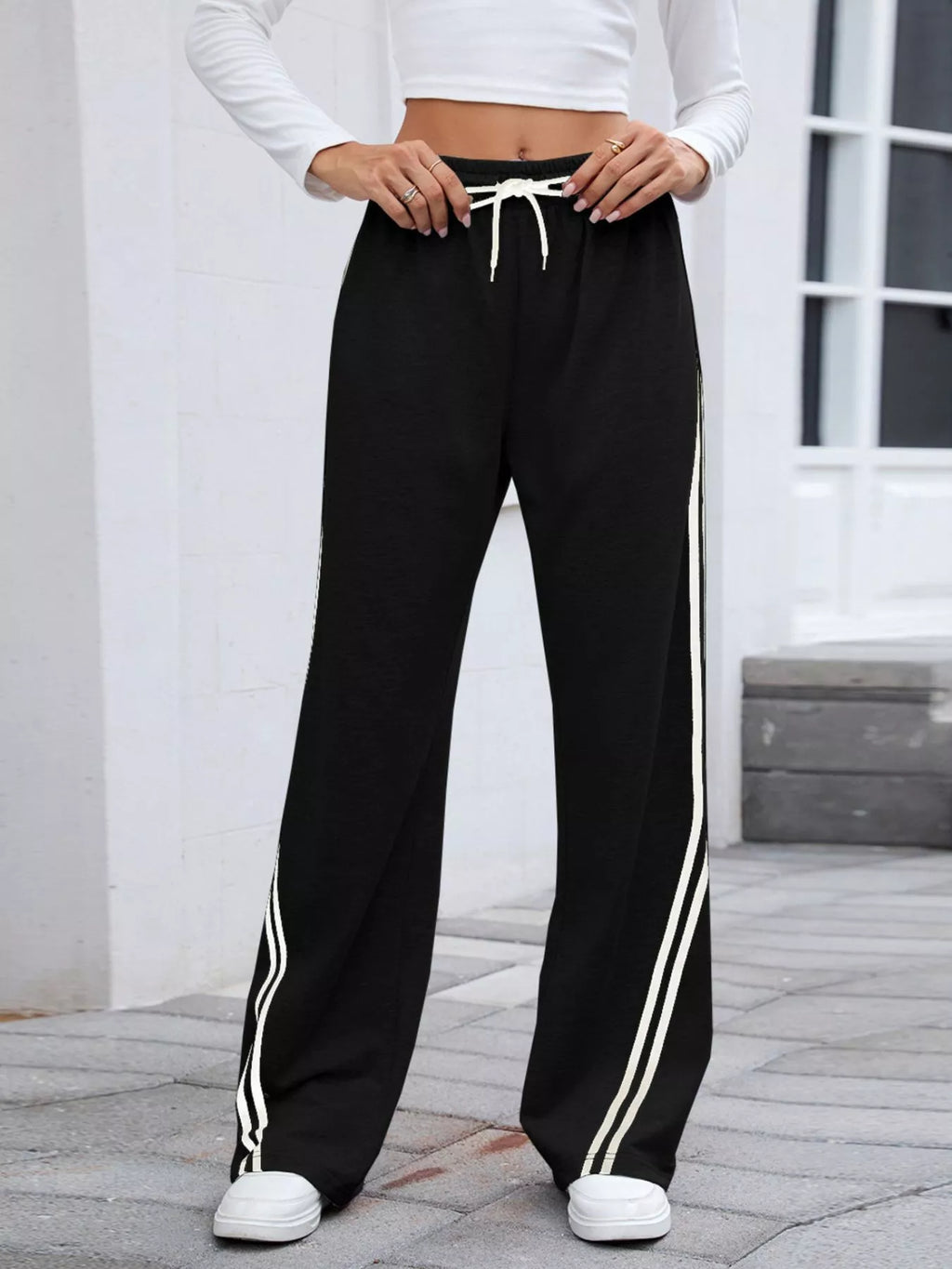 woman wearing drawstring athletic pants with side stripe