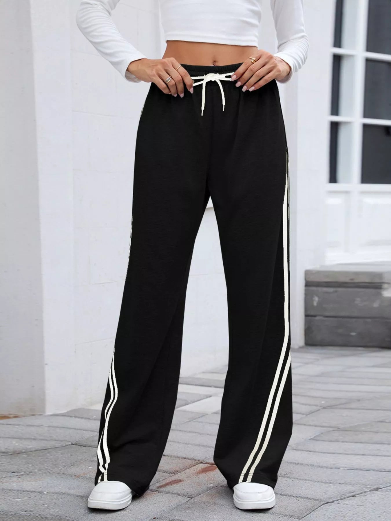 woman wearing drawstring athletic pants with side stripe