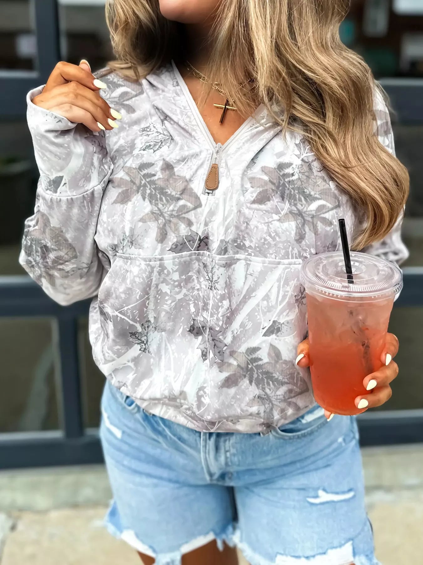 woman wearing a half zip camo pattern hoodie