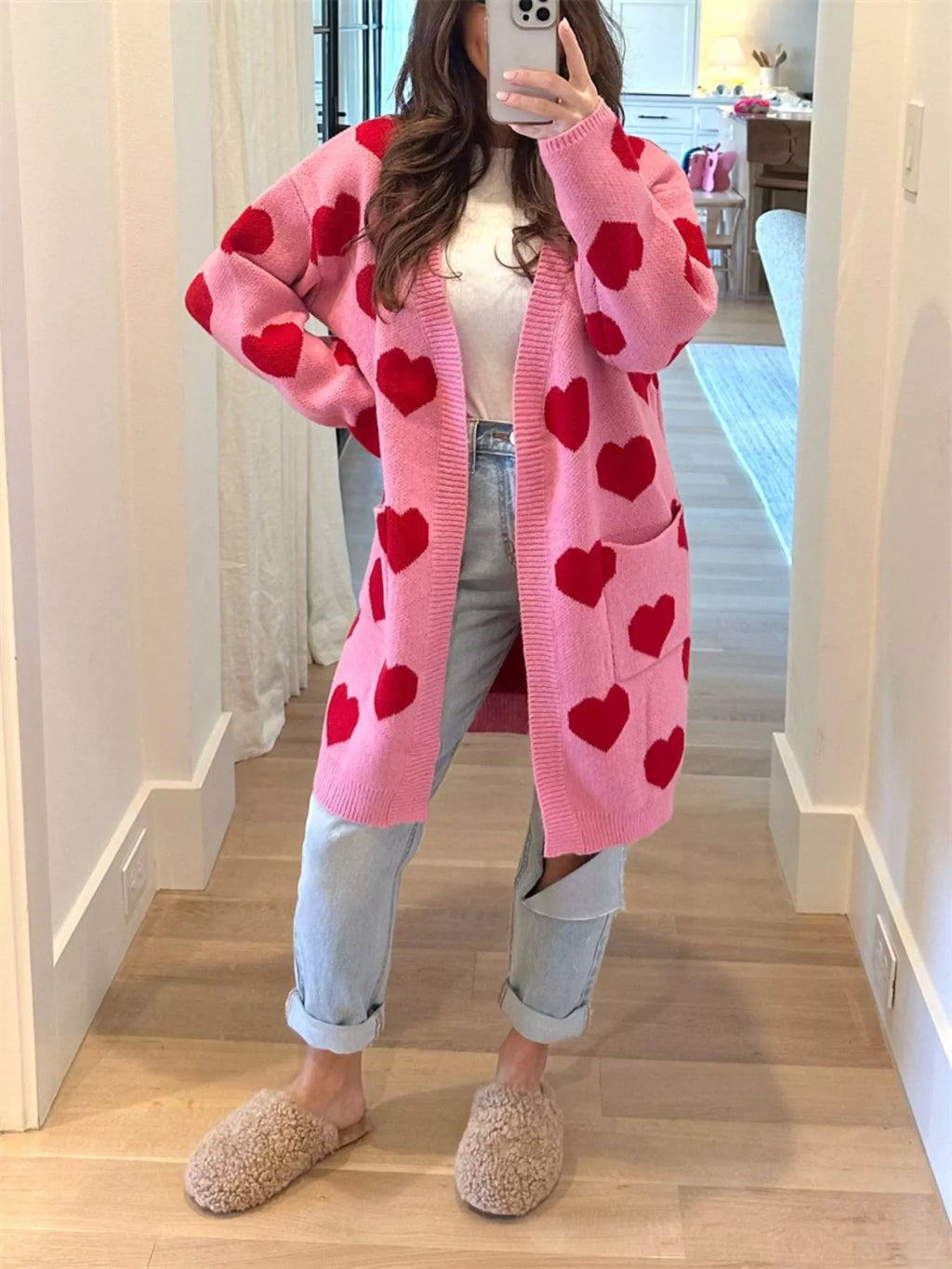 woman wearing a trendy women’s cardigan with pockets and heart pattern