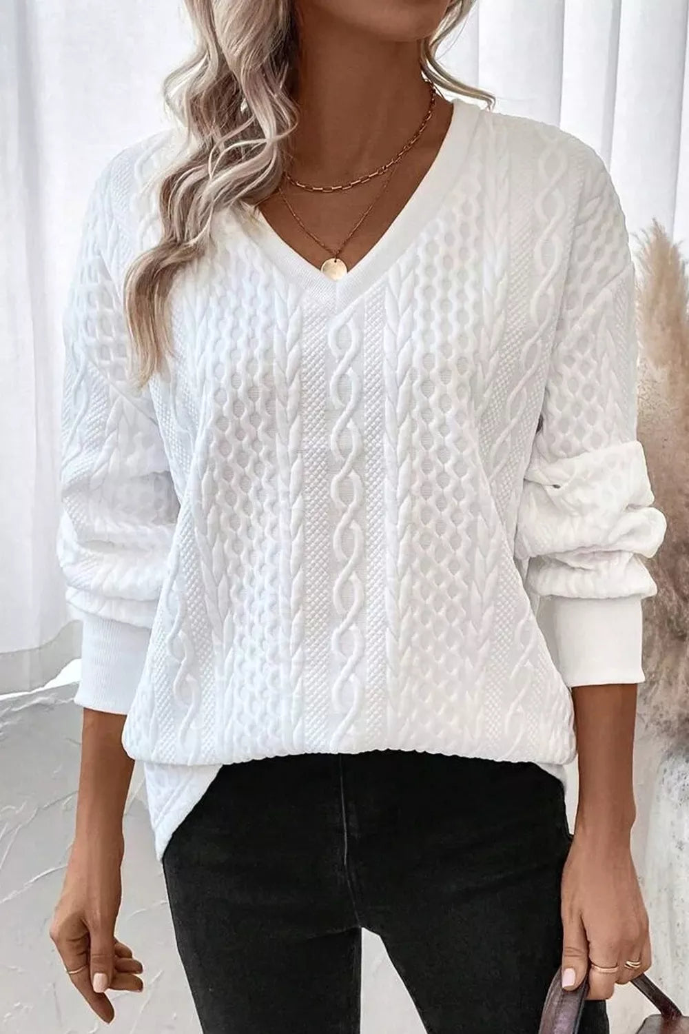 woman wearing a v neck textured trendy white sweater
